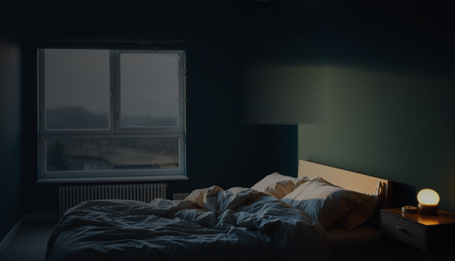 A quiet Nordic bedroom at dusk, unmade bed, cool light through the window, warm lamp on the nightstand